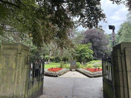 The entrance gates and flower beds of Calder Holmes Park in Hebden Bridge