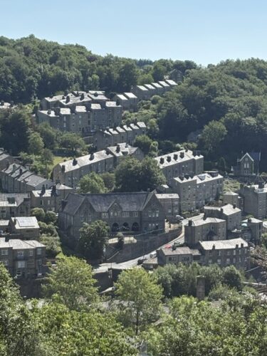 Stone terraced houses on the wooded hillside above Hebden Bridge, the setting for Riot Women