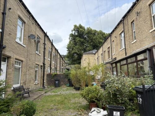The cobbled back lane of Linden Place in Hebden Bridge, with the conservatory of Catherine Cawood's house