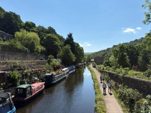 Narrowboats moored along the Rochdale Canal towpath in Hebden Bridge, a Happy Valley filming location